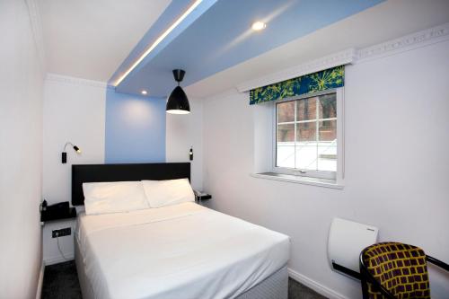 a bedroom with a white bed and a window at St James Hotel; BW Premier Collection in Nottingham
