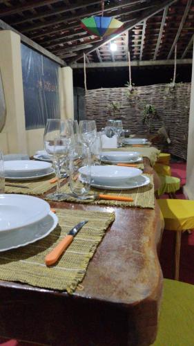 a table with plates and wine glasses on it at Parador Algaroba in Japaratinga