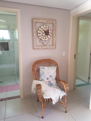 a wicker chair with a pillow in a room at Casa- Maresias 3 minutos da praia in Maresias