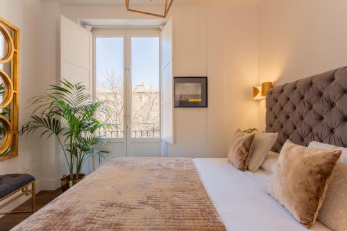 a bedroom with a large bed and a window at Bib Rambla Luxury Apartments in Granada