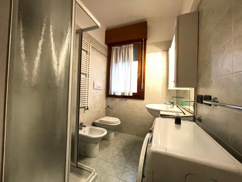 een badkamer met een toilet, een wastafel en een bad bij RESIDENCE IPANEMA - WALTERIGATO Apartments SOLO PER FAMIGLIE in Lido di Jesolo