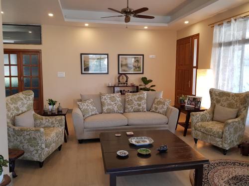 a living room with a couch and chairs and a table at Shalom Farmhouse by the hillside in Imphal