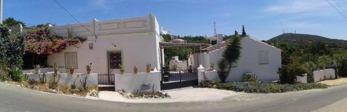 a white house sitting on the side of a street at Casa Da Cabeça in Faro