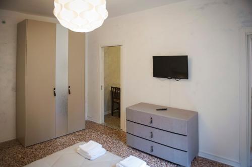 a room with a dresser and a tv on a wall at Porta Orientalis Venice in Venice