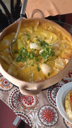 a pot of soup with a spoon on a table at Parador Algaroba in Japaratinga