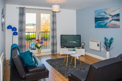 a living room with a tv and a couch and a table at Grand Central Friar Gate Deluxe in Derby