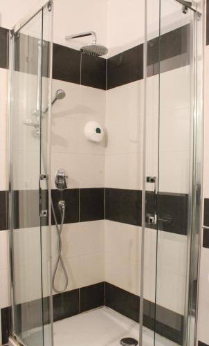 a shower with black and white tile in a bathroom at Hôtel Alexandra in Roquebrune-Cap-Martin