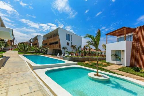 a swimming pool in front of a house at Departamento Las Palmeras de Bocapán 201 in Zorritos