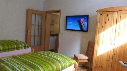 a bedroom with a bed and a tv on the wall at Ferienwohnung Oberlungwitz in Oberlungwitz