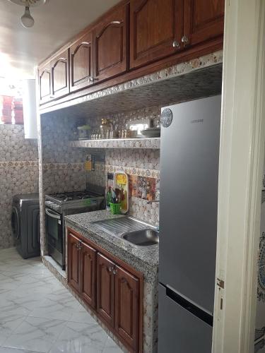 a kitchen with a sink and a refrigerator at Residence Bassatine in Temara