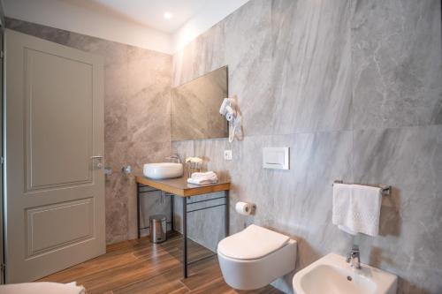 a bathroom with a sink and a toilet and a mirror at Borgo di Drugolo in Lonato del Garda