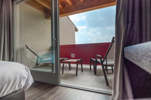 a bedroom with a balcony with a table and chairs at Borgo di Drugolo in Lonato del Garda