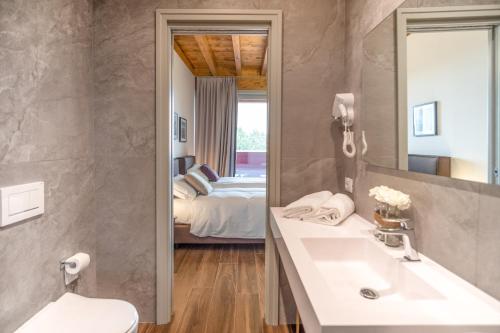 a bathroom with a sink and a bedroom at Borgo di Drugolo in Lonato del Garda