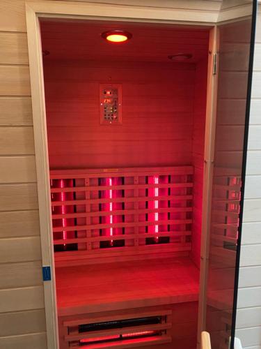 a sauna with pink lighting in a house at Au p’tit loup in Bastogne