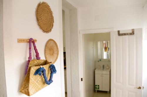 a hallway with a white wall with a purse hanging on a wall at Caparica Downtown Apartment in Costa da Caparica