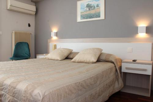een slaapkamer met een bed met 2 kussens erop bij Hôtel Alexandra in Roquebrune-Cap-Martin