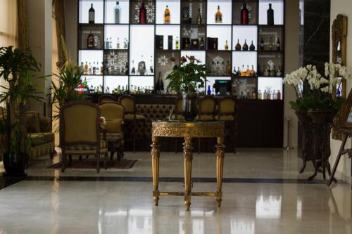 a room with a table and a shelf of bottles at Fiori Hotel in Erbil