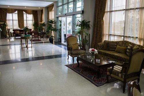 a living room with a couch and chairs and a table at Fiori Hotel in Erbil