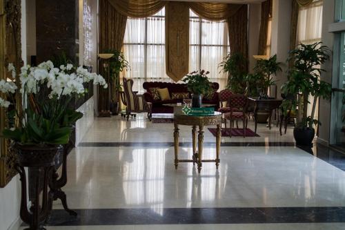 a lobby with plants and a table with flowers at Fiori Hotel in Erbil