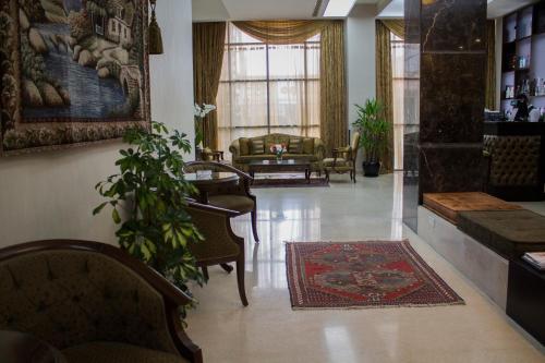 a living room with chairs and a rug on the floor at Fiori Hotel in Erbil