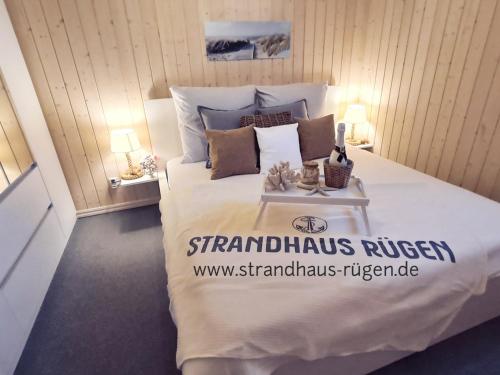 a bedroom with a large bed with a white comforter at Strandhaus Rügen - Meerblick, Sauna, Kamin & Whirlpool in Baabe