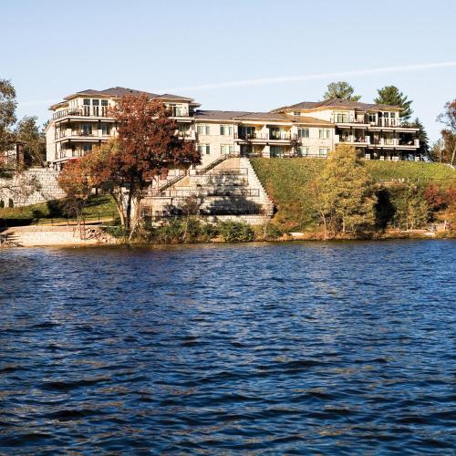 a large building on the shore of a body of water at Delton Grand Resort in Wisconsin Dells
