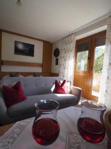 two glasses of red wine on a table in a living room at Gästehaus Hechenblaikner in Maurach