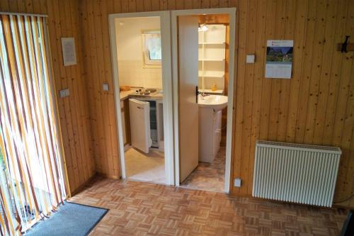 a small bathroom with a sink and a mirror at Ferienhaussiedlung am Chossewitzer See in Friedland