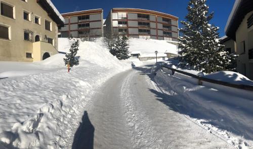 a snow covered road in front of a building at Chesa Panorama in Celerina