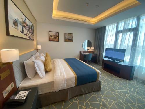 a hotel room with a bed and a television at Velar Inn Hotel in Taif