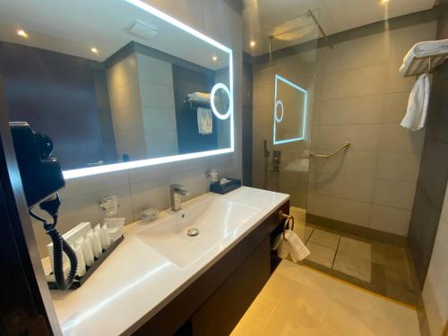 a bathroom with a sink and a large mirror at Velar Inn Hotel in Taif