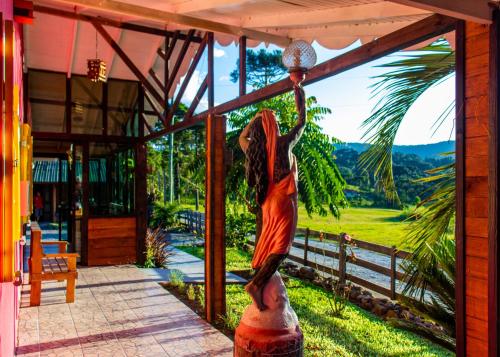 a statue of a woman holding a ball on a porch at Hospedagem Rural Recanto do Riacho in Urubici