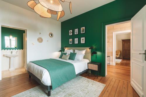 - une chambre verte avec un lit et un lustre dans l'établissement Villa Les Belles Saisons, à Saint-Émilion