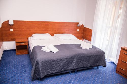 1 dormitorio con 1 cama grande y cabecero de madera en Willa Koala, en Karpacz