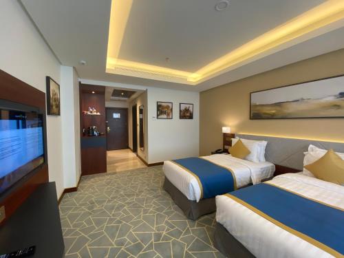 a hotel room with two beds and a flat screen tv at Velar Inn Hotel in Taif