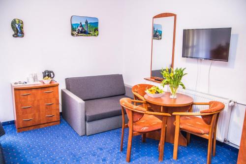 een woonkamer met een tafel en een stoel bij Willa Koala in Karpacz