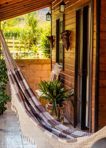 a hammock on the porch of a house at Hospedagem Rural Recanto do Riacho in Urubici