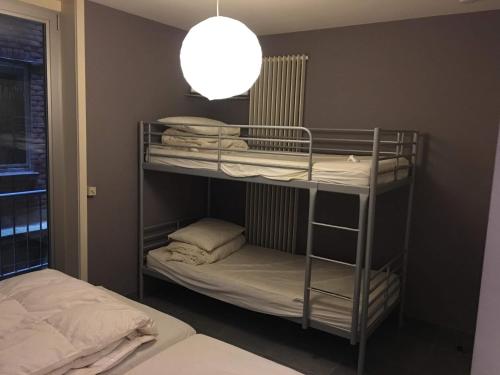 a room with two bunk beds and a lamp at Gelijkvloers zeezicht appartement Sterckx in Blankenberge