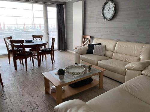 a living room with a couch and a table at Gelijkvloers zeezicht appartement Sterckx in Blankenberge
