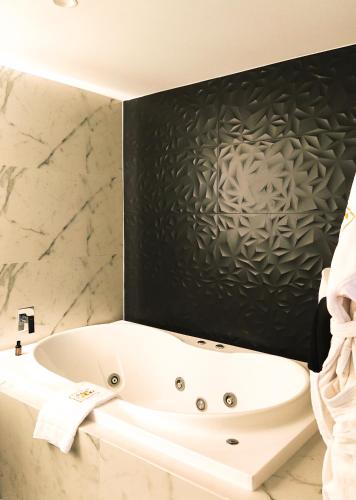 a white bath tub in a bathroom with marble walls at Ramë Hotel Boutique in Guadalajara