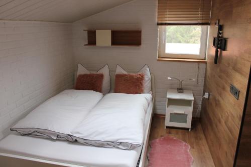 a small bed in a tiny room with a window at Apartment Ferienhaus in Würzburg