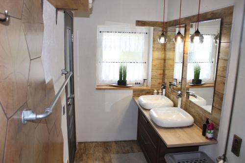 a bathroom with two sinks and a mirror at Apartment Ferienhaus in Würzburg