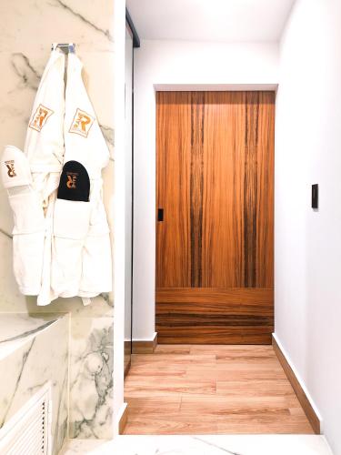 a hallway with a white jacket hanging in front of a wooden door at Ramë Hotel Boutique in Guadalajara