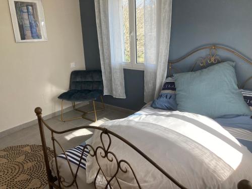 Un dormitorio con una cama, una silla y una ventana en Sitio Nathalie et Jos, en Saint-Laurent-de-Carnols