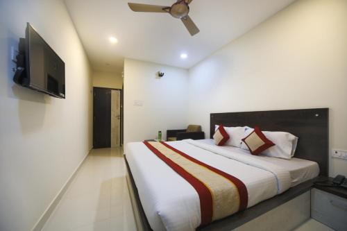 a bedroom with a large bed and a flat screen tv at Balaji residency in Chennai