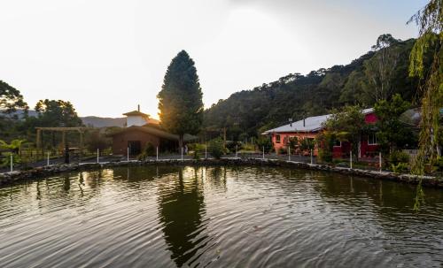 a large pond in front of a building at Hospedagem Rural Recanto do Riacho in Urubici