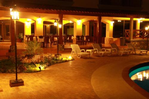 a patio with chairs and a pool at night at Gran Hotel Azuero in Chitré
