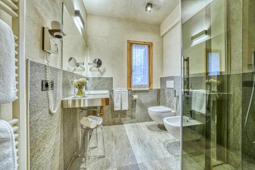 a bathroom with a toilet and a sink and a shower at Hotel Sant'Orso - Mountain Lodge & Spa in Cogne