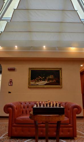 a living room with a couch and chessboard on a table at Phi Hotel Dei Medaglioni in Correggio