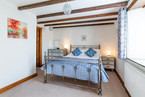 a bedroom with a bed and a window at Tregolls Farm Cottages in Wadebridge